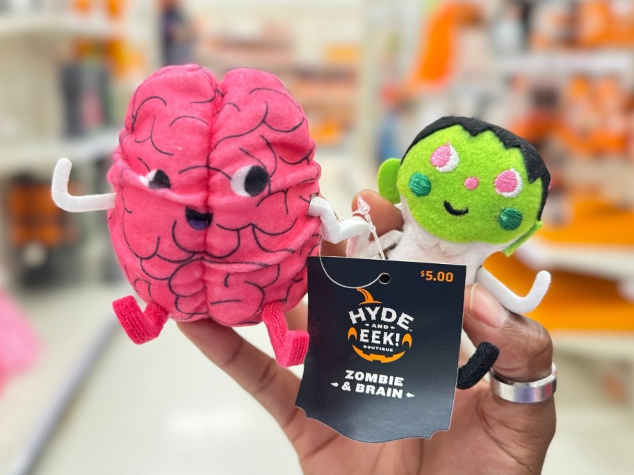 hand holding a felt duo of a brain and a zombie