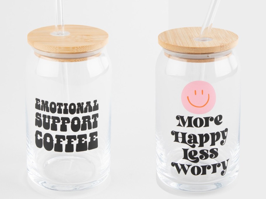 2 glass tumblers with bamboo lids, 1 says "emotional support coffee", the other has a pink smiley face and says "more happy, less worry"