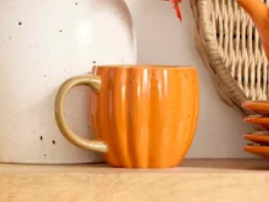 an orange and tan pumpkin shaped coffee mug