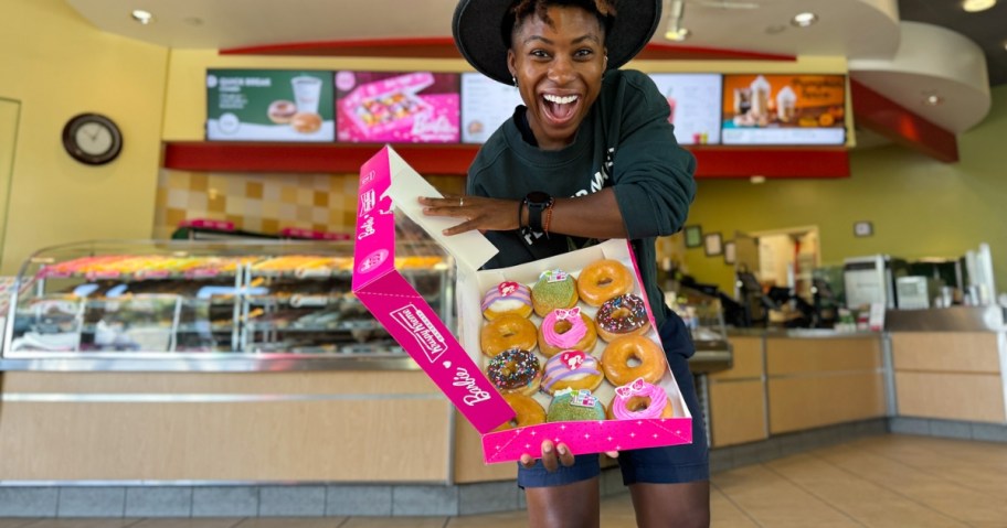 woman holding barbie krispy kreme dozen in restaurant