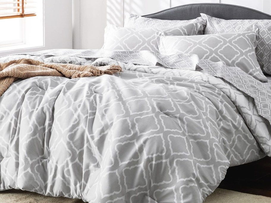 grey and white geometric lattice print onlineforter with matching shams on a bed