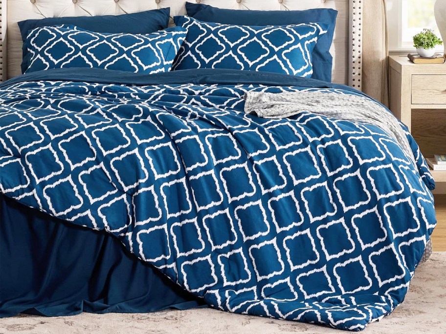 blue and white geometric lattice print onlineforter with matching shams on a bed