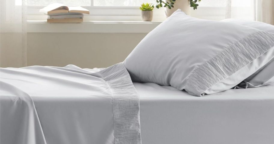 A bed with grey sheets