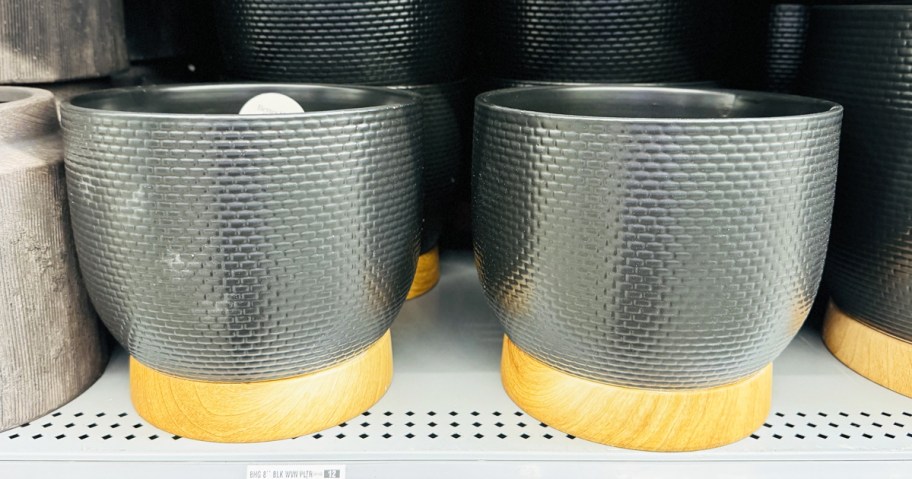 black planters with woven patterns on store shelf