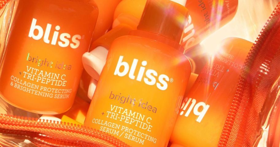 Bottles of Bliss Vitamin C Serum in a clear orange makeup bag