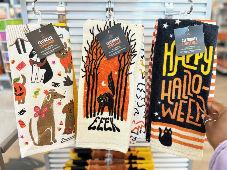 hand touching halloween kitchen towels in store