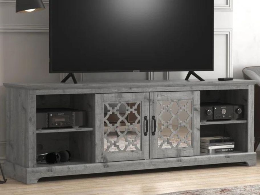 A Chessani TV Stand with a large TV stand on it