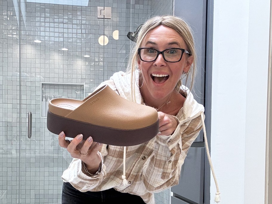 woman holding up a platform crocs clog