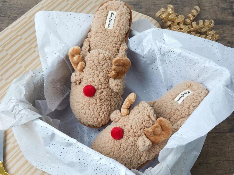 A shoebox with a pair of Dearfoams Reindeer Slippers in it