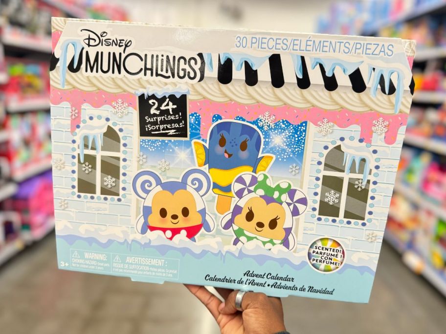 a womans hand holding a disney munchlings advent calendar