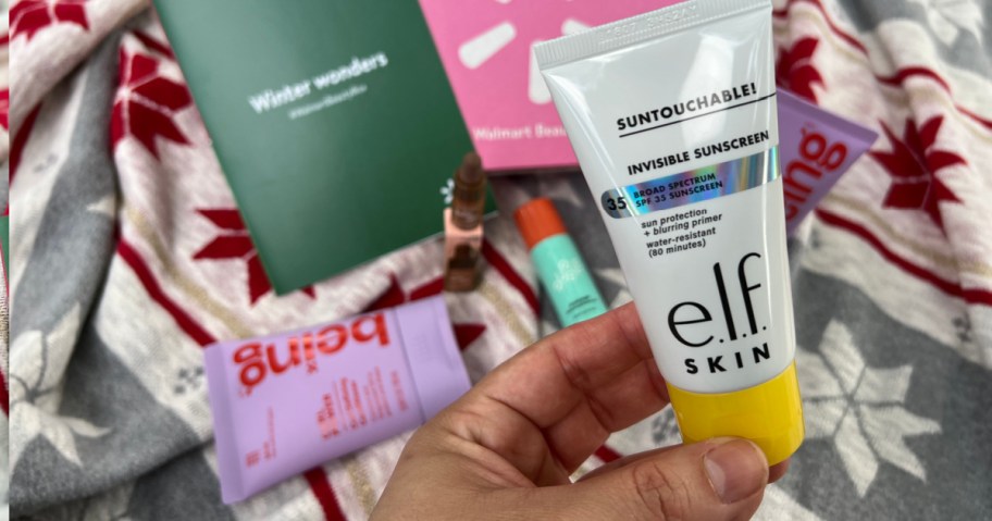 Woman holding up small bottle of elf sunscreen