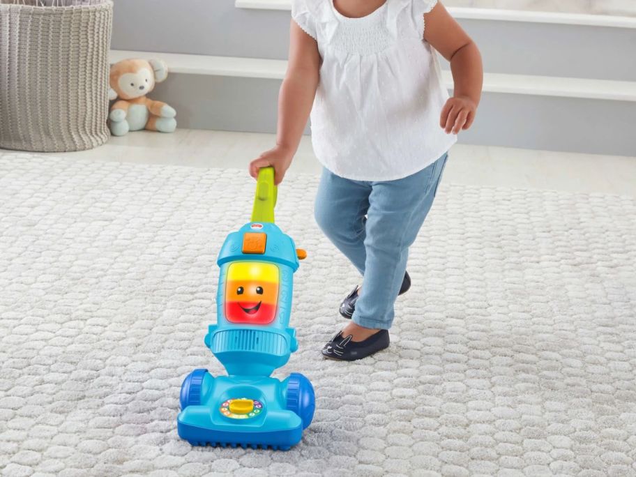 kid playing with Fisher-Price Laugh & Learn Light-Up Learning Vacuum