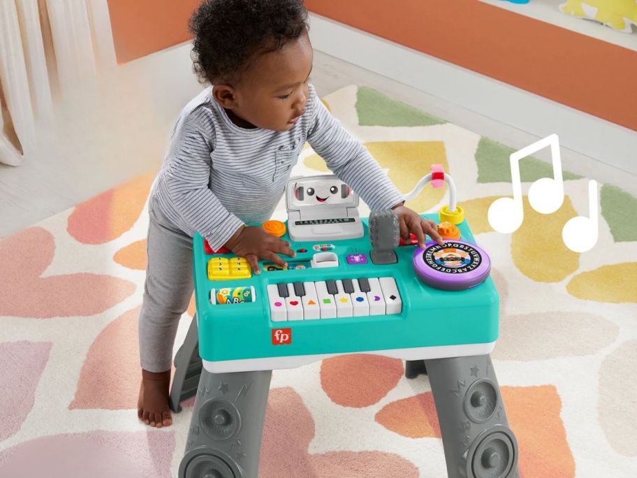 baby playing with Fisher-Price Laugh & Learn Mix & Learn DJ Activity Table