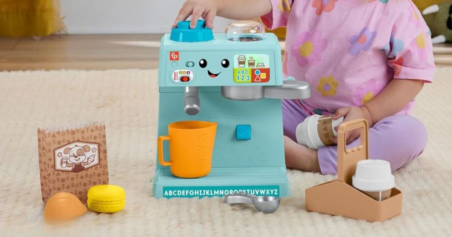 kid playing with Fisher-Price Laugh & Learn & Serve Coffee Cafe Playset