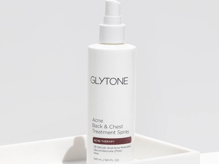 bottle of Glytone Back & Chest Acne Treatment Spray in a white tray