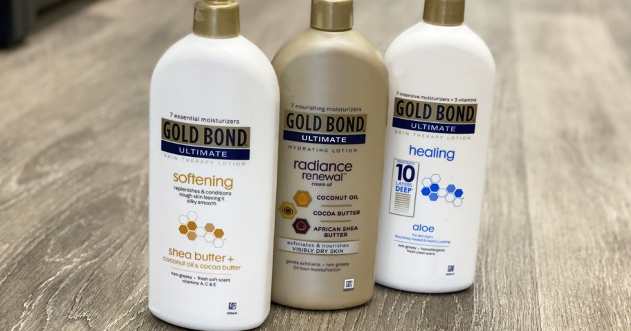 three bottles of Gold Bond body lotion on floor of store