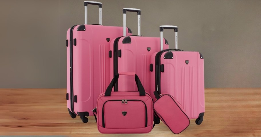 a 5 piece set of pink luggage, 3 hardside spinner luggage pieces in various sizes, a carryon bag and cosmetic bag