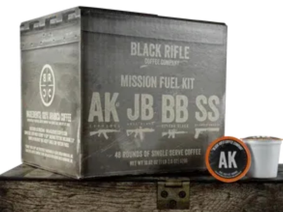 large box of Black Rifle onlinepany Mixed Coffee Rounds K-Cups with 2 k-cups in front, setting on top of a wooden crate