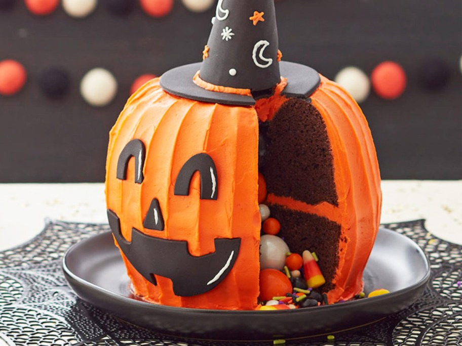 3d pumpkin cake with sprinkles and candies onlineing out from the center