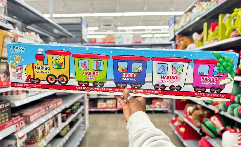 a womans hand holding a haribo goldbears holiday train box