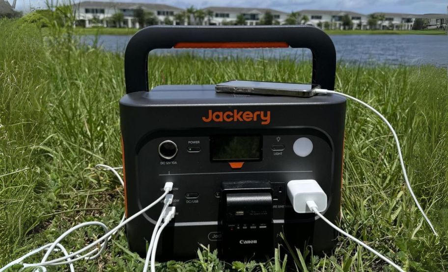 jackery power station shown outdoors with multiple devices plugged in