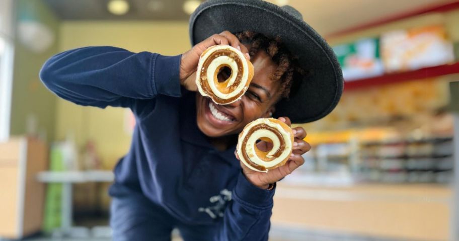 girl holding 2 donuts over her eyes