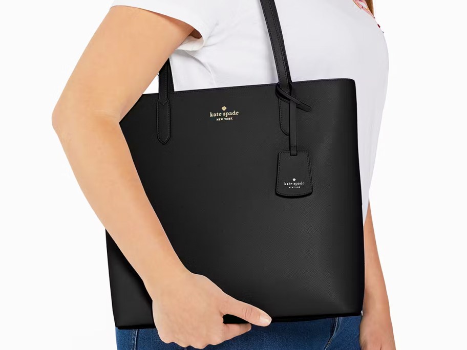 woman in white tee with black tote bag