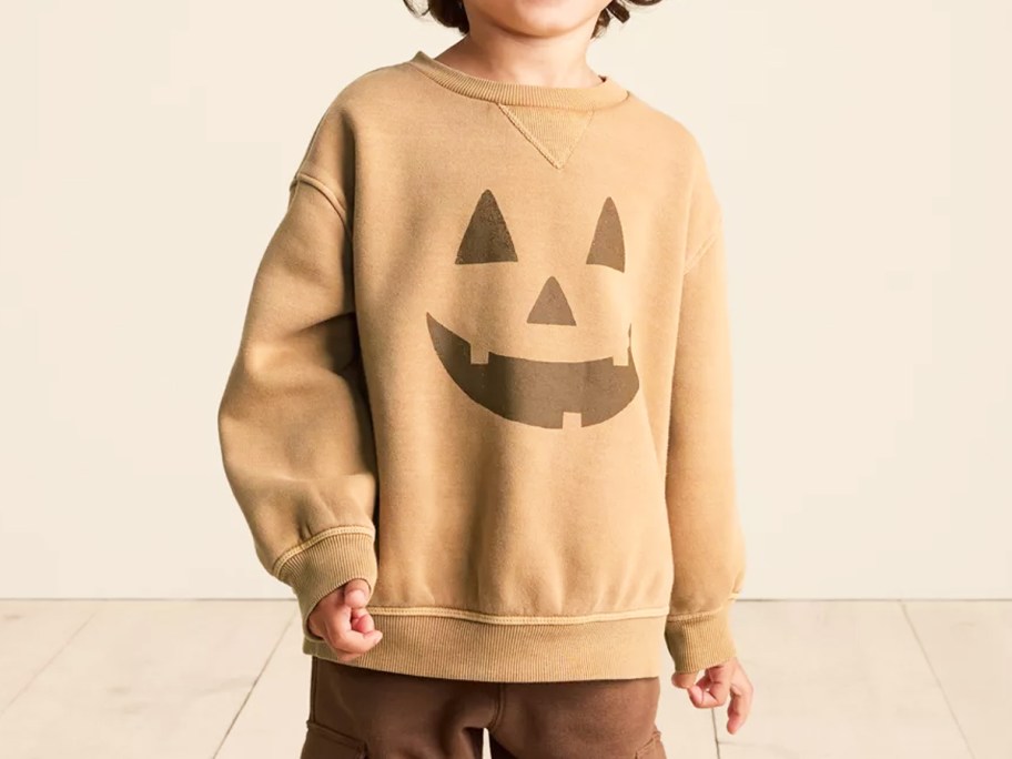 boy in a jack o lantern face sweatshirt