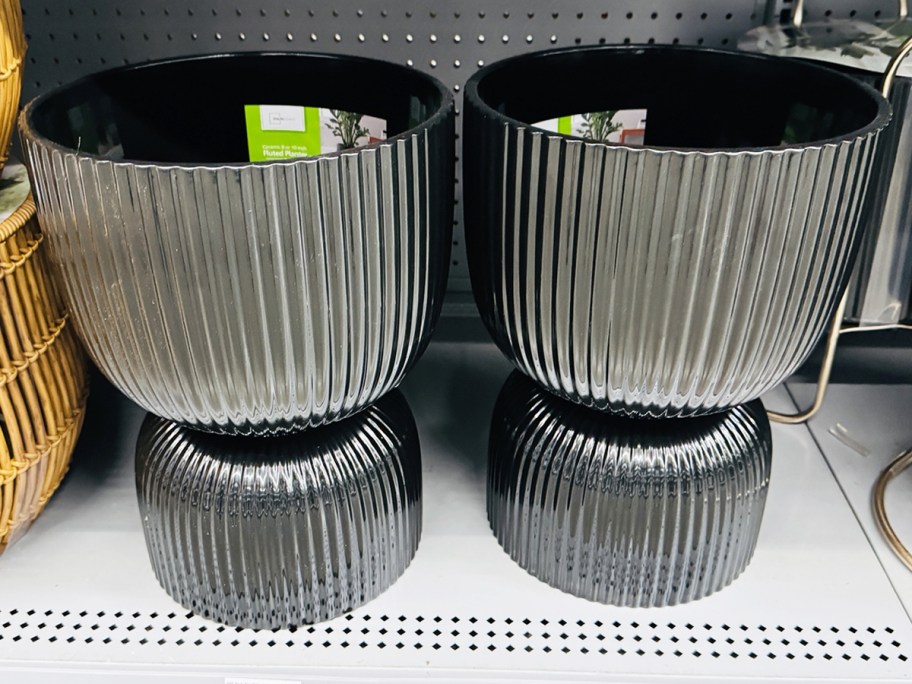 two large black planters on store shelf