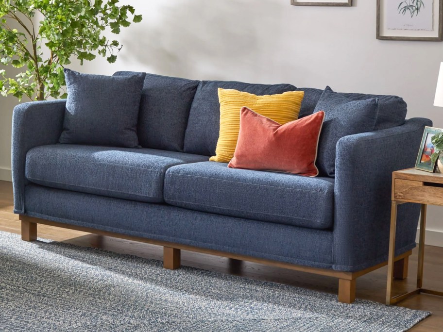 blue sofa with throw pillows on it