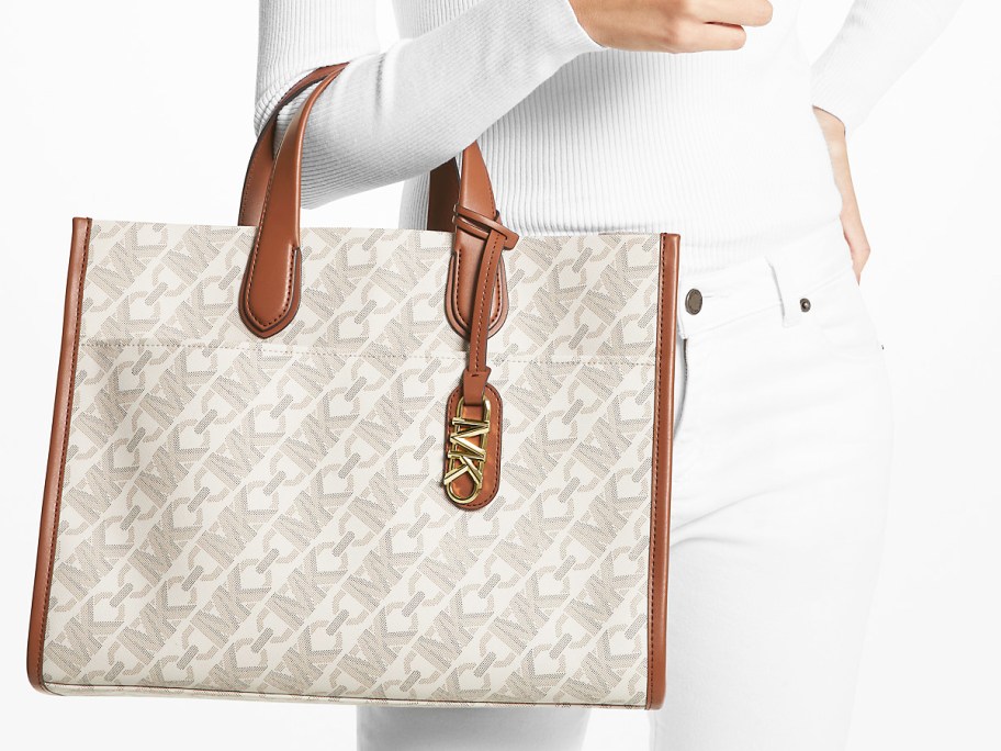 woman in a white outfit with a white and brown tote bag