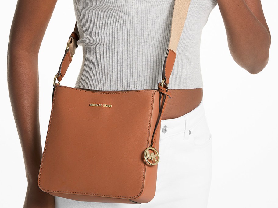 woman with a brown leather crossbody messenger bag