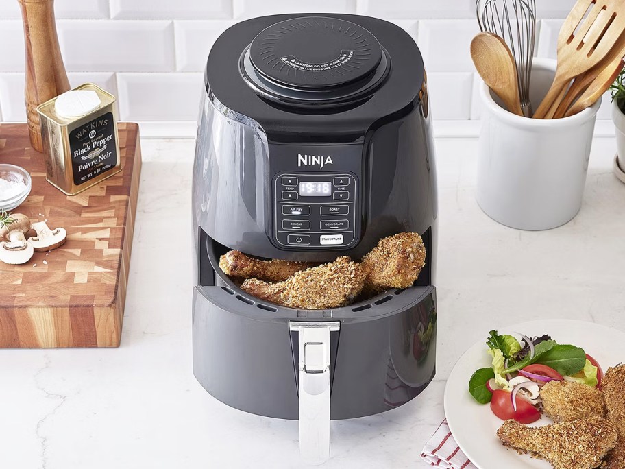 Ninja 4-Quart Air Fryer on counter with basket open and chicken inside