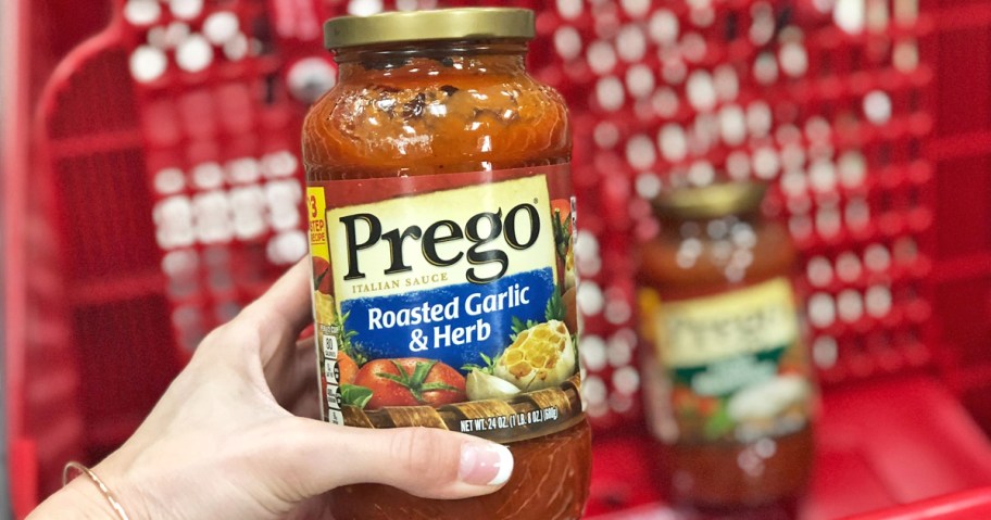 hand holding up a jar of prego pasta sauce