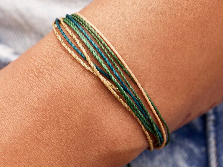 arm with green and blue bracelet