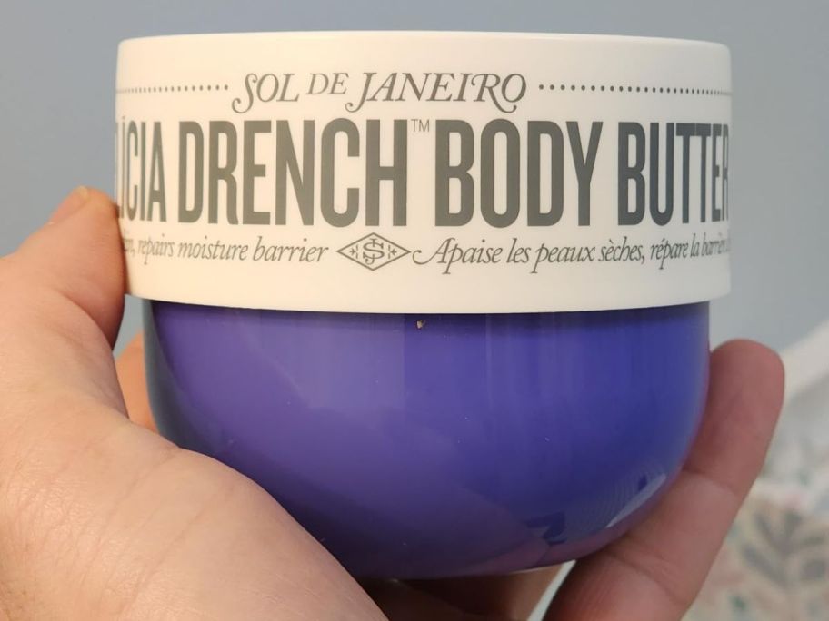 Hand holding a jar of Sol de Janiero No. 59 Deliciosa Body Drench Butter