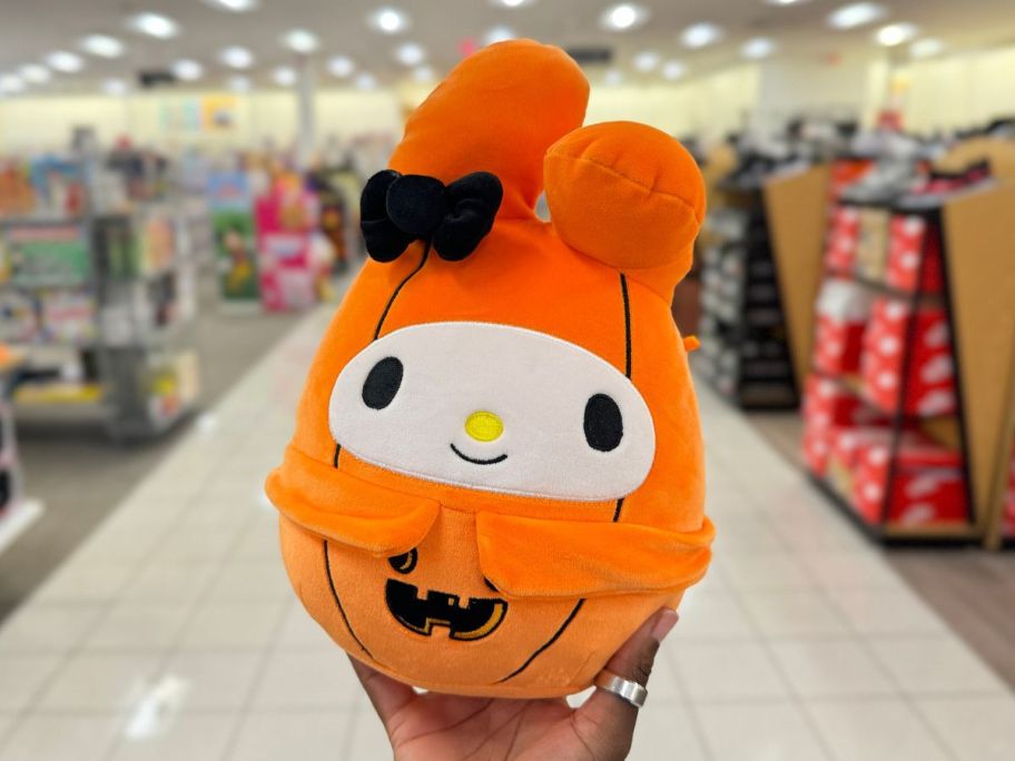 hand holding Squishmallows 8' Hello Kitty Melody Pumpkin in store