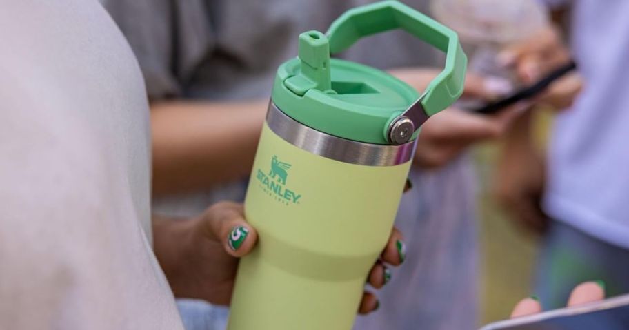 Hand holding a green Stanley Iceflow Flip Tumbler