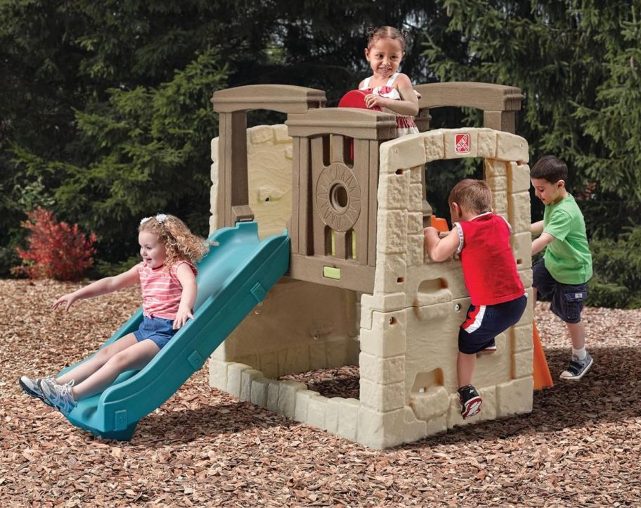 4 little kids playing on a step2 wooden climber playset