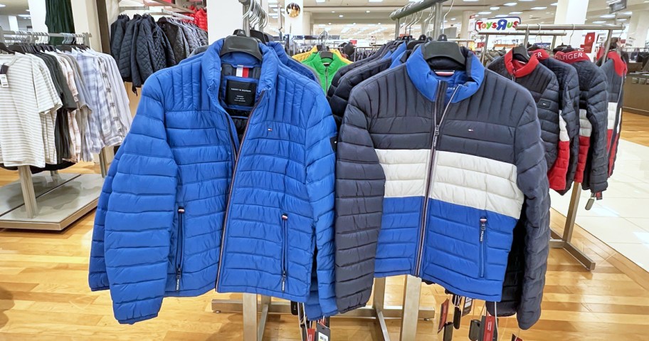 Tommy Hilfiger puffer jackets hanging on display rack in macy's store