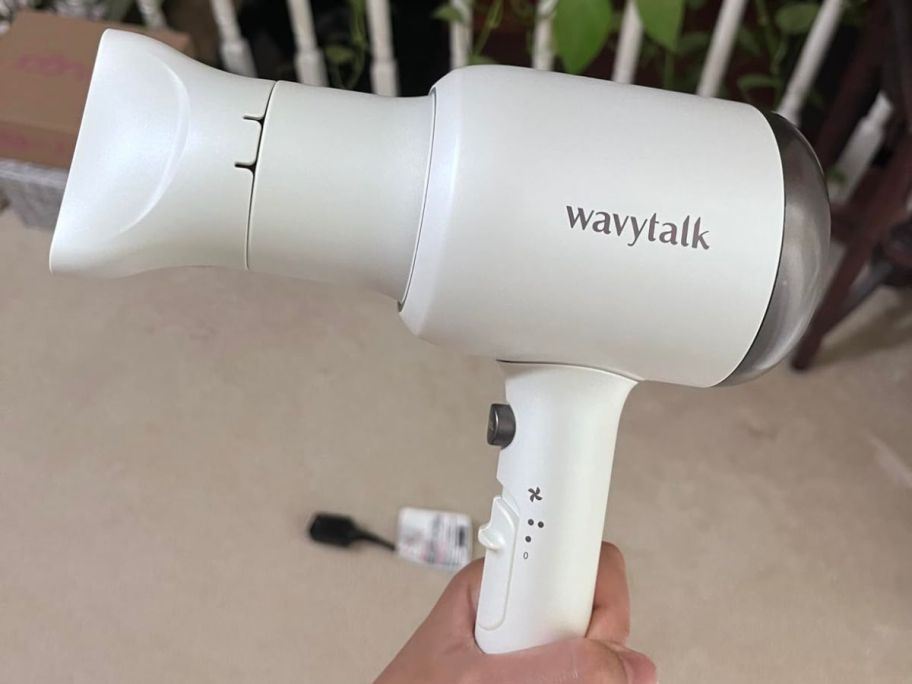 A person holding a Wavytalk Hair Dryer in white