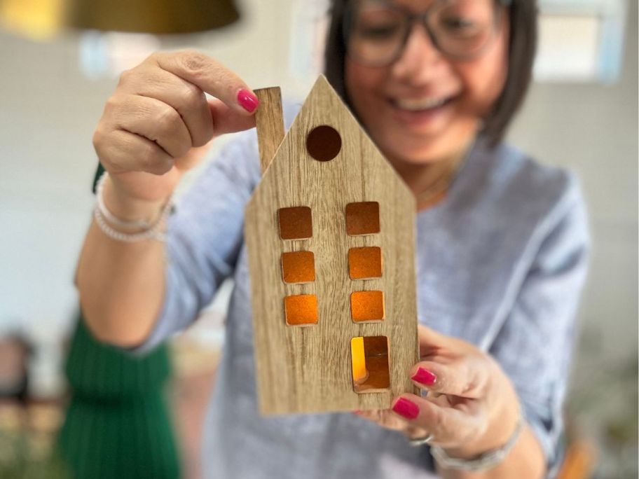 woman holding Wondershop 7" Lit Wood House w/ Round Window Christmas Village Building