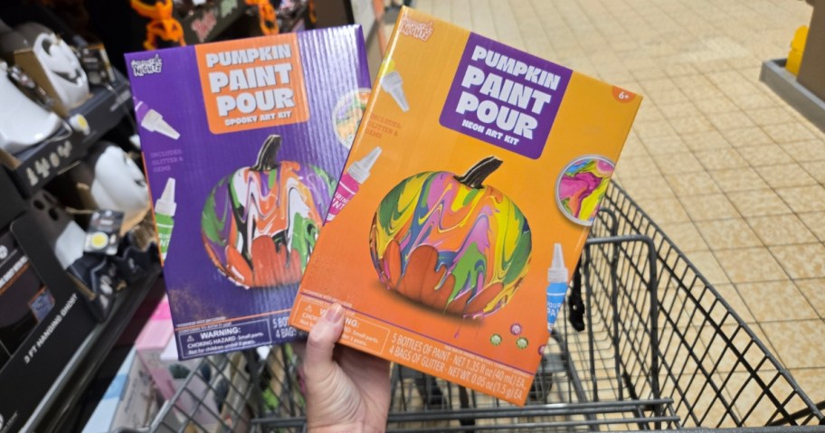 hand holding 2 pumpkin painting kits