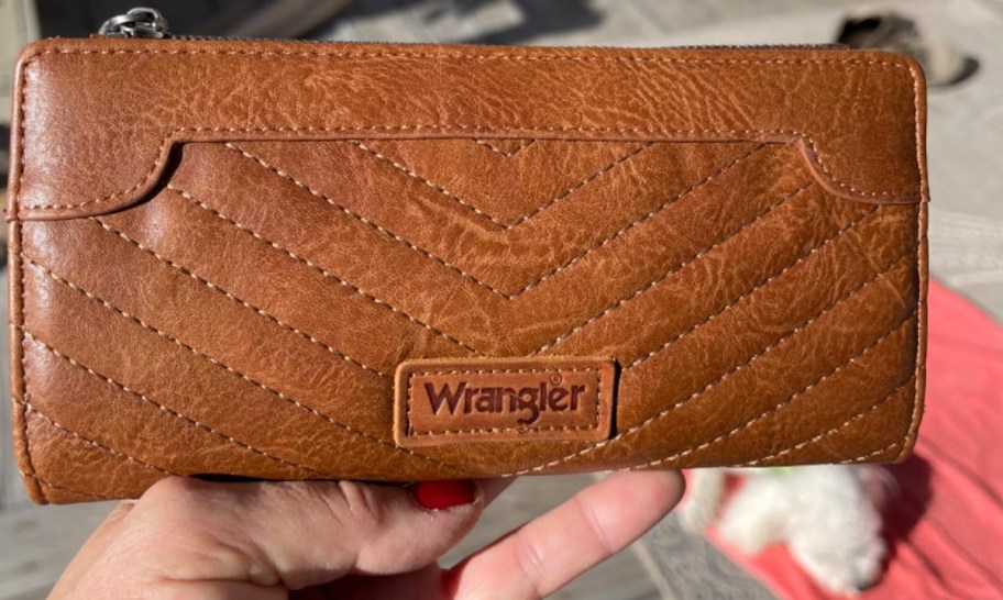 hand holding brown wrangler wallet