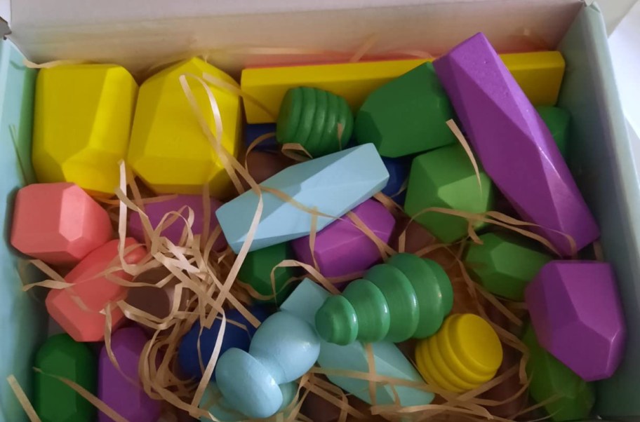 box filled with stacking stones in different colors