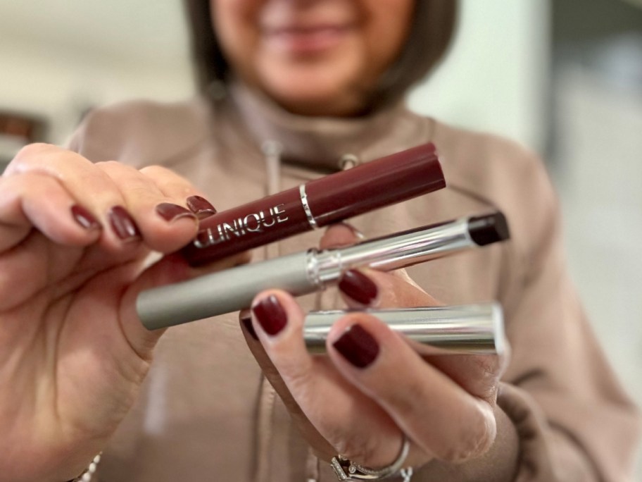 woman holding two lipsticks