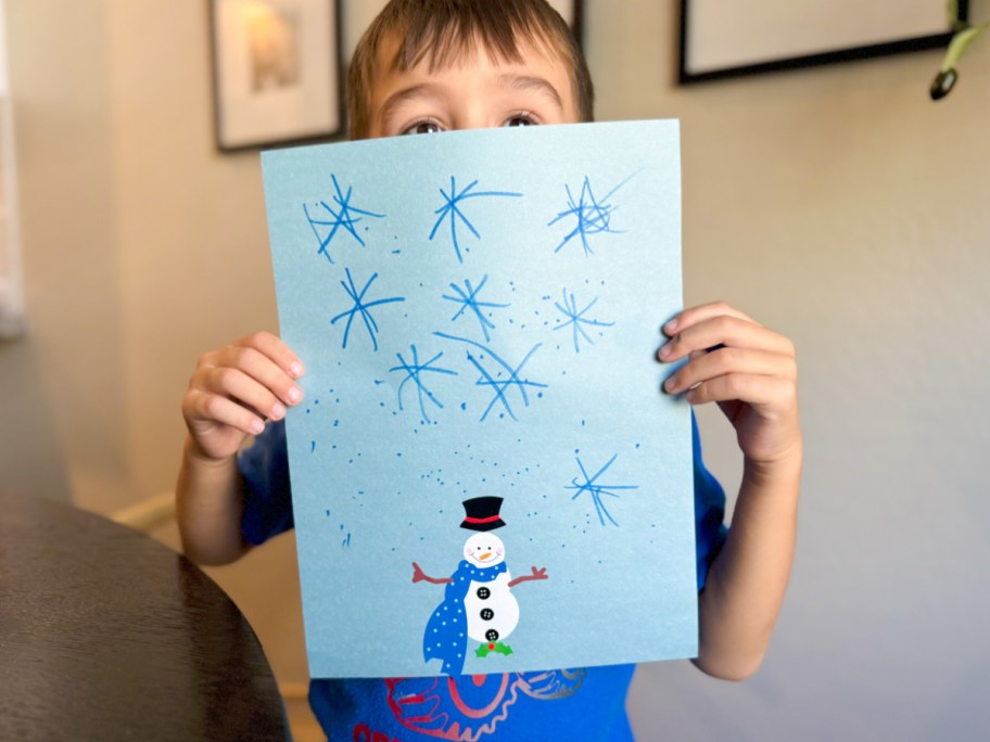 boy holding up artwork