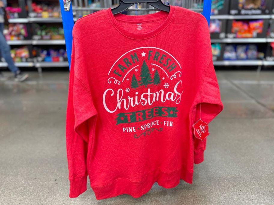 farm fresh Christmas trees sweatshirt hanging on the side of a walmart shopping cart