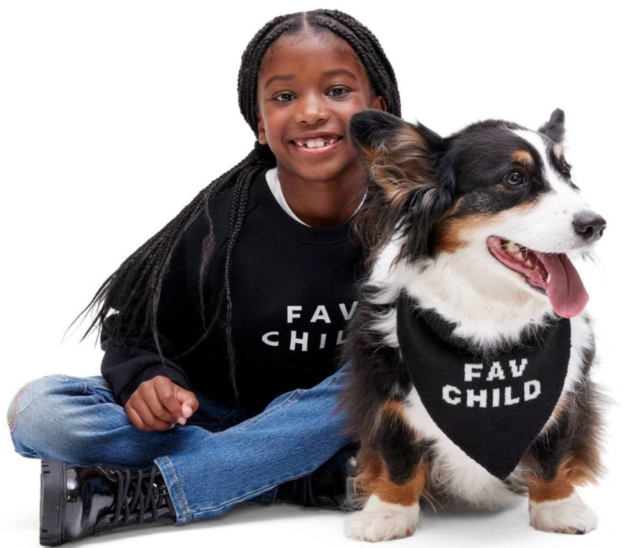 a girl and her dog wearing matching sweatshirt and bandana