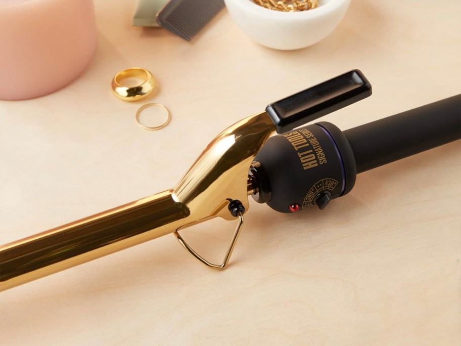 gold and black curler on table